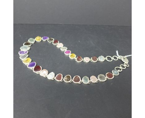 A silver necklace set with raw gemstones in colletr mounts to include aquamarine, amethyst, citrine, garnet and rose quartz, 