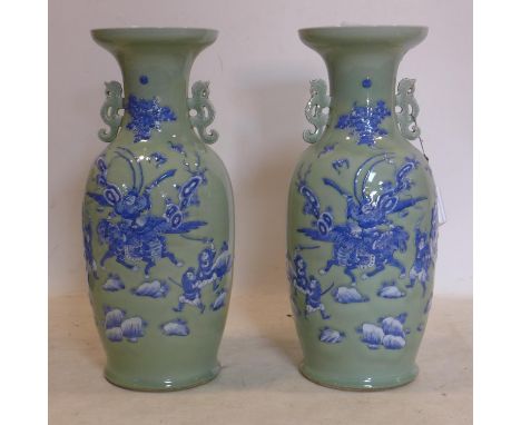 A pair of early 20th century Chinese vases, one broken, decorated in blue and white with warriors in a battle scene on a ligh