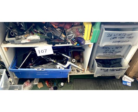 A quantity of loose bike parts, including tubes, cables, a set of front forks, saddle, clamps, and some hand tools. (Contents