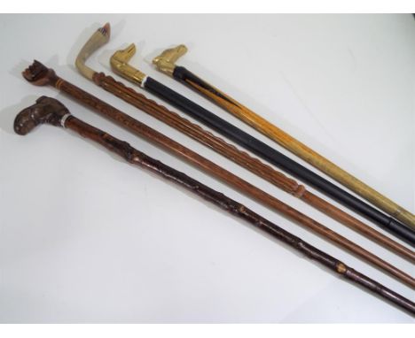 Walking sticks - five walking sticks to include one with carved wooden handle in a form of boot with white metal detailing, m