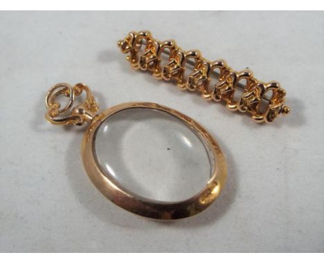 A hallmarked 9 carat gold and glass pendant with 9 carat gold surround, approximately measures 4 cm in length and a gilded ba