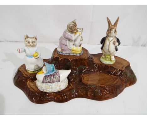 Beswick - a Beswick ceramic tree trunk stand with four Beatrix Potter figurines to include Mr Benjamin Bunny, Tabitha Twitchi