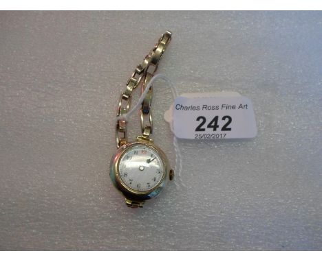 A lady's 9 carat gold cased dress watch, the white enamel dial bearing Arabic numerals, to a yellow metal bracelet.