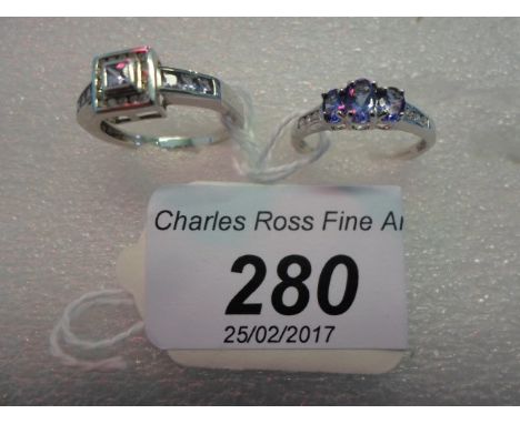 A three stone tanzanite ring with diamond set shoulders, together with a tanzanite and diamond square shaped cluster ring.
