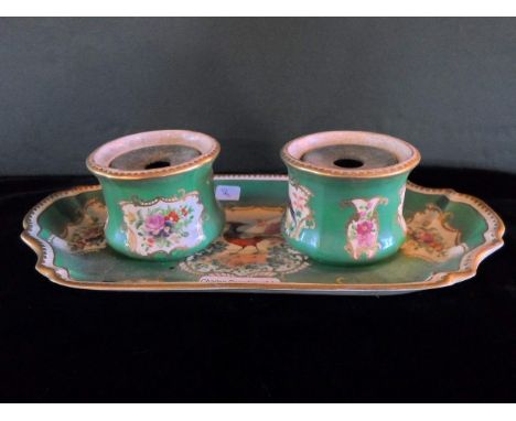 A 19th century twin inkwell and stand, possibly French, having hand painted floral and bird sprays on a green ground with gil