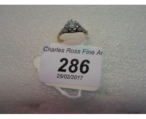 A single stone diamond ring, the brilliant cut diamond in raised claw mounted coronet setting above engraved shoulders and pl