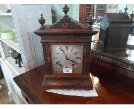 An oak cased mantle clock, the silvered dial bearing Roman numerals, the coil gong striking movement signed W & H, (36cm).