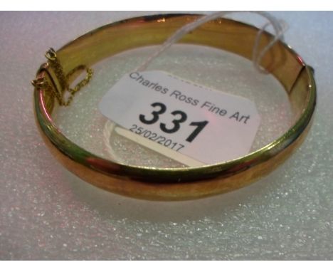 A 9 carat gold bangle, part scroll and foliate engraved, push button opening, Chester 1912, in fitted case.   Condition Repor