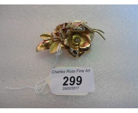 A two colour 18 carat gold and diamond spray brooch, modelled as two flower heads and a bud amongst leaves, the centres set w