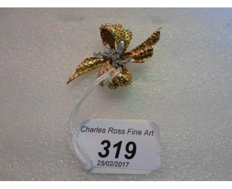 An 18 carat gold and and diamond stylized ribbon form spray brooch, the central brilliant cut diamond spray within textured r