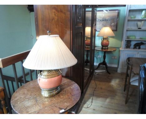 A pair of ceramic and brass mounted table lamps, each with conical silk shade, (68cm tall).