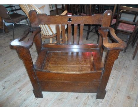 An early 20th century oak hallstand/single seater bench, having a lift flap seat flanked by twin stick stands, (91cm wide).