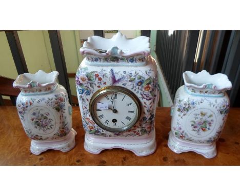 A Continental clock garniture, having hand painted floral decoration throughout, the circular enamel dial bearing Roman numer
