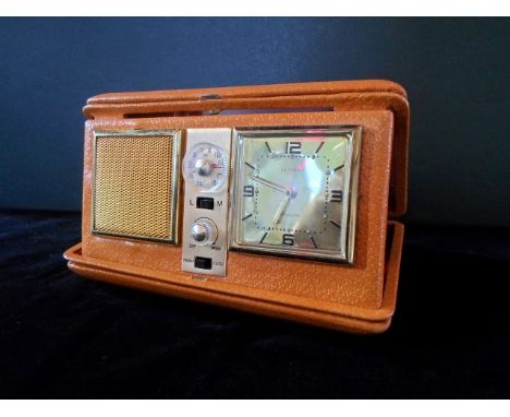 A mid-20th century boxed Estyma purse travelling alarm clock and radio.