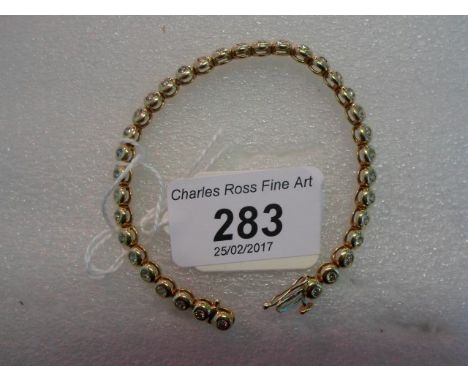 An 18 carat gold and diamond line bracelet, the brilliant cut diamonds in rub-over circular links.   Condition Report:  Yello