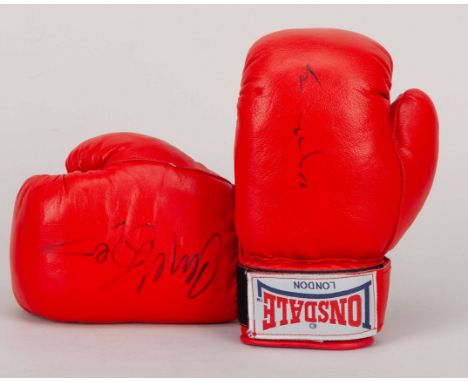 A pair of boxing gloves signed by British boxing rivals Nigel Benn and Chris Eubank, both red Lonsdale left-hand gloves signe