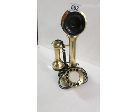 A modern brass candlestick telephone.