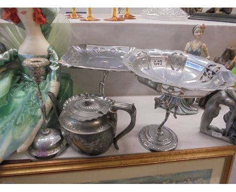 Two metal cake stands with figural bases, a candlestick and a teapot.
