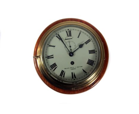 A brass-cased marine bulkhead clock c1920s: by Kelvin White & Hutton of London, bevel glazed front-opening polished brass cas