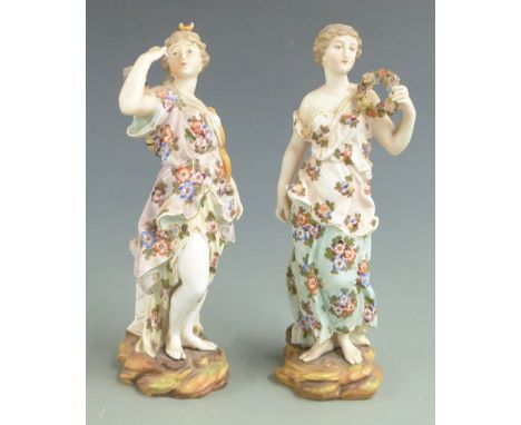 A pair of late 19th/20thC Volkstedt porcelain figurines carrying a garland and a bow and quiver emblematic of love, H 17.5cm