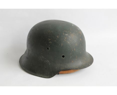 A WWII GERMAN HELMET, worn decal to side, impressed number, appears to read D 3260, with detached liner