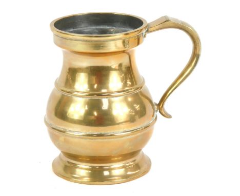 A brass quart tankard, with shaped handle and moulded bands, marked V R 29, 17cm high. 