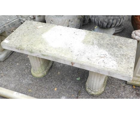 A reconstituted stone garden bench, the rectangular top on two oval plinths, each set with sunflower and Corinthian columns, 