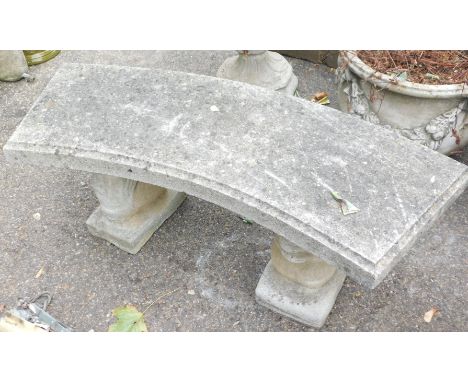 A reconstituted stone garden bench, the curved top on squirrel supports, 44cm high, 94cm wide, 37cm deep.