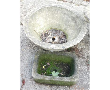 Two  reconstituted stone planters, comprising a circular planter, 60cm high, and a rectangular stone hewn trough, 39cm wide. 