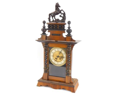 An early 20thC walnut mantel clock, with Vienna style fret moulded horse top, brass and ceramic numeric dial, 72cm high, 31cm