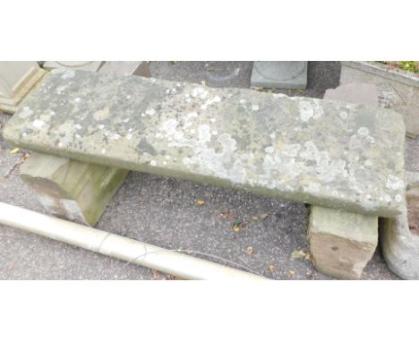 A stone garden bench, converted from two sectional base and later top, matched, 40cm high, 114cm wide, 52cm deep.