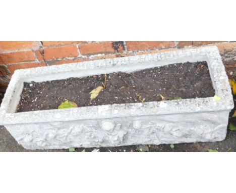 A reconstituted stone rectangular planter, with seven relief moulded cherub figures, 28cm high, 91m wide, 31cm deep. 