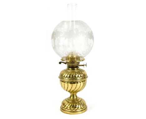 A 19thC brass oil lamp, with domed floral glass shade, on a fluted stem, 40cm high. 