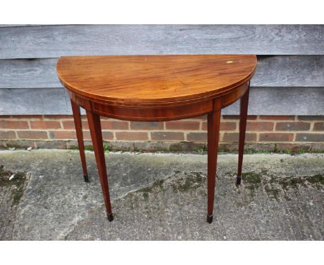 A 19th century mahogany and line inlaid semi-circular fold over top card table, on square taper supports, 36" wide x 18" deep