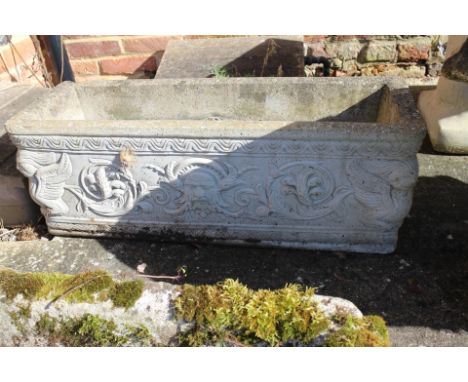 A cast concrete rectangular planter with classical mask decoration, 28 1/2" x 9 1/2"