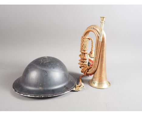 A British military black painted tin helmet, a brass bugle and a WWII gas mask