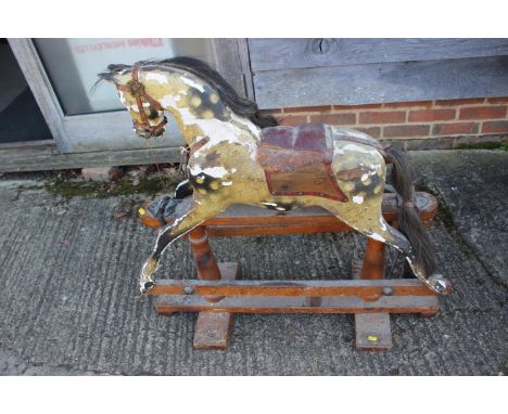 A Victorian carved and painted rocking horse, 34" high (paint losses and one glass eye missing)