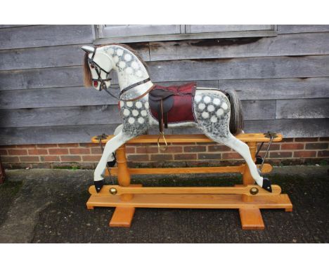 A carved rocking horse, painted dapple grey, 48" high