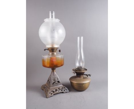 An early 20th century oil lamp with etched shade, chimney and clear glass reservoir, on cast metal base with scrolled decorat