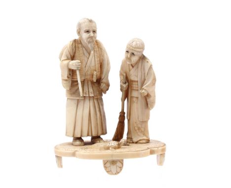 Carved ivory depiction of an old man with a stick and a child with a broom with a turtle and fish on the ground, Japan Meiji 