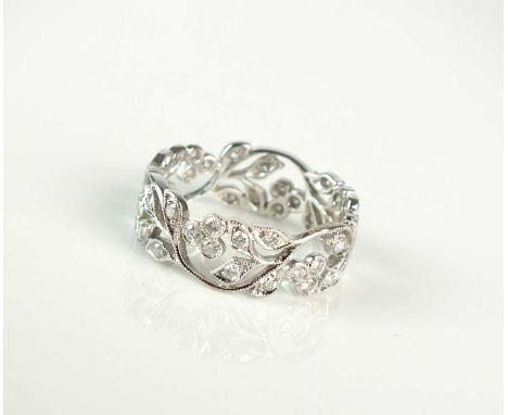 A diamond set decorative floral pierced band, the brilliant cut diamonds claw set in white metal, stamped '750', ring size M,