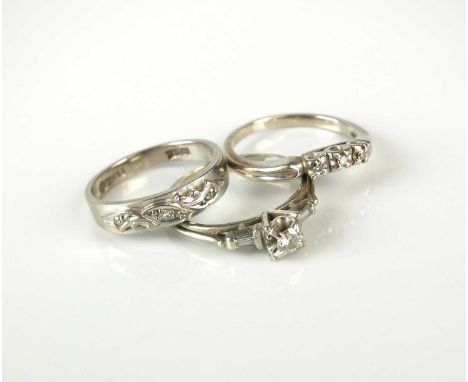 A single stone diamond ring, with baguette cut diamond set shoulders, the white metal shank stamped '18ct', size J, together 