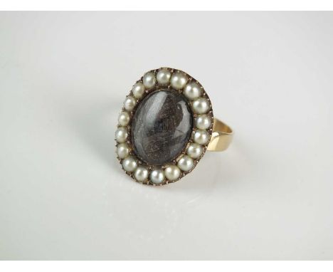 A 19th century split seed pearl and plaited hair mourning ring, the oval plaited hair plaque mounted within a border of split