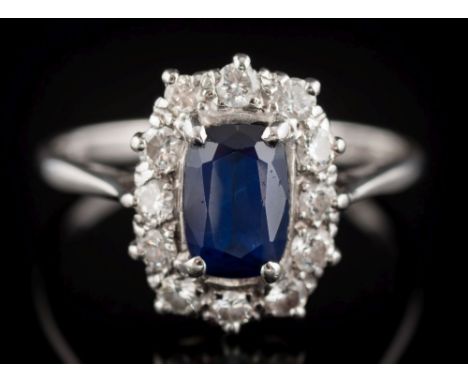 A sapphire and diamond oval cluster ring: the central oval sapphire approximately 7.6mm long x 5.1mm wide x 2.8mm deep, in fo