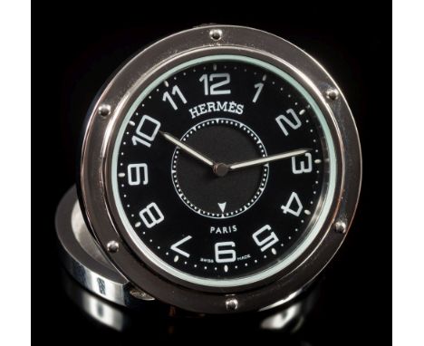 Hermes. A stainless steel travel alarm clock: the circular black dial 36mm diameter with Arabic numerals, luminescent hands, 