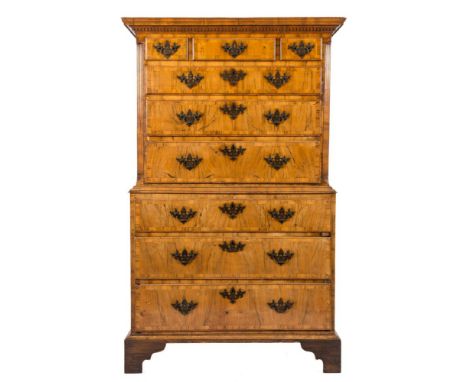 An early 18th Century walnut and crossbanded tallboy:, the upper part with a moulded dentil cornice, containing three short a