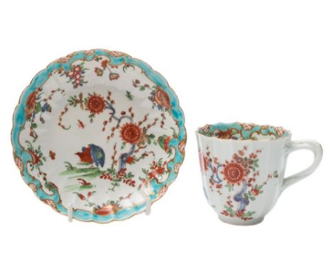 A First Period Worcester cup and saucer: of fluted form, the cup with entwined twig handle, painted in the kakiemon palette w
