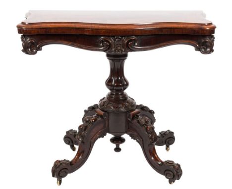 A Victorian carved rosewood card table:, of serpentine outline with a baize lined hinged top, having a moulded edge and shape