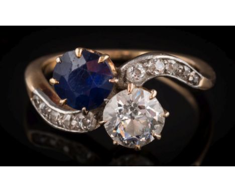 A sapphire and diamond two-stone crossover ring: the round, old brilliant-cut diamond 6.5mm diameter x 4mm deep, estimated to