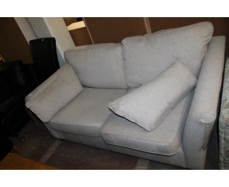 A OATMEAL COLOURED TWO SEATER UPHOLSTERED SOFA 